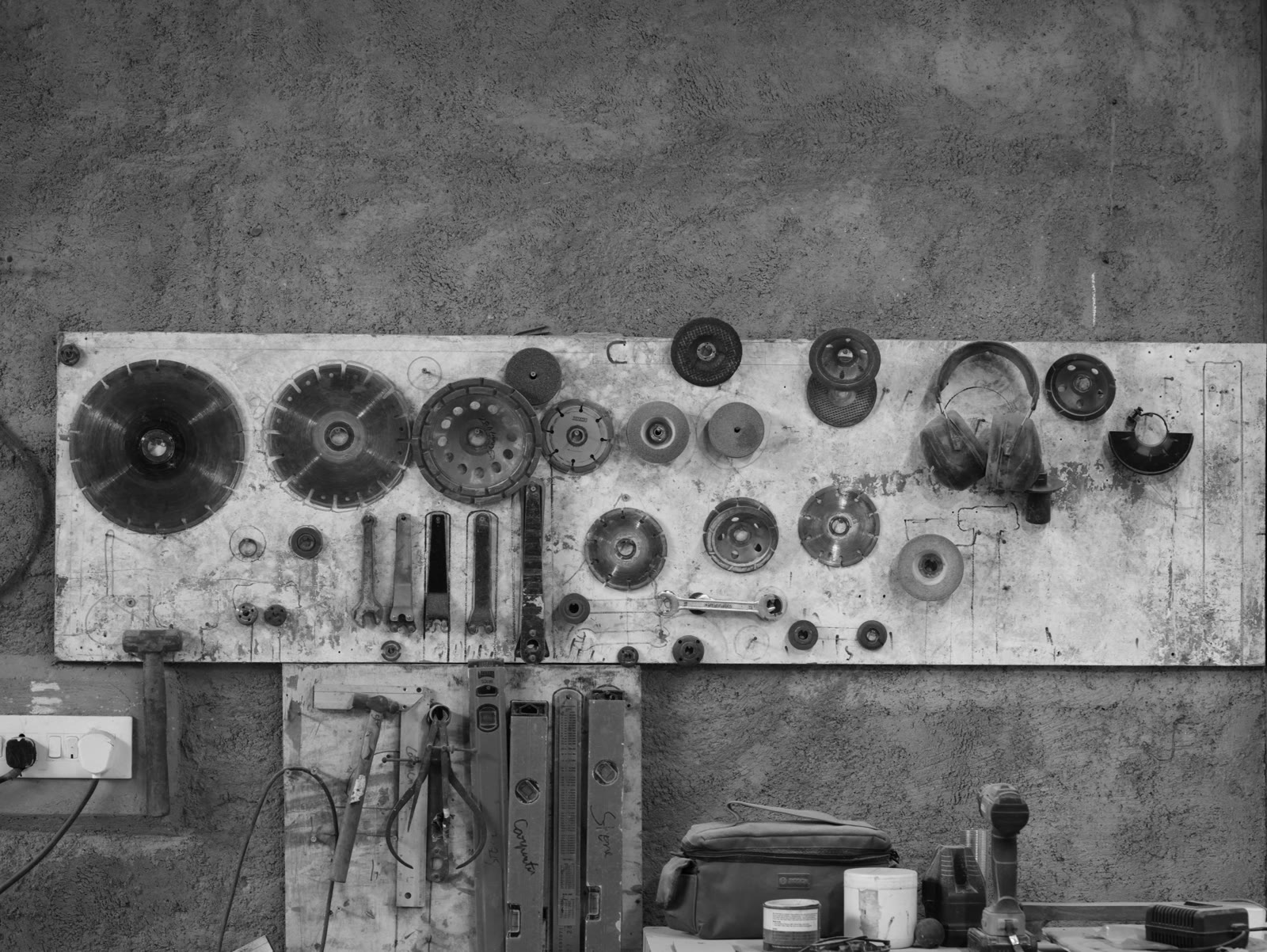 Workshop cutting, carving and finishing tools arranged on a wall
